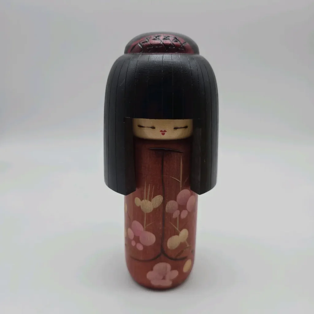 Sosaku kokeshi "Haregi" by Shin'ichiro, a girl in a red festive kimono with plum blossoms